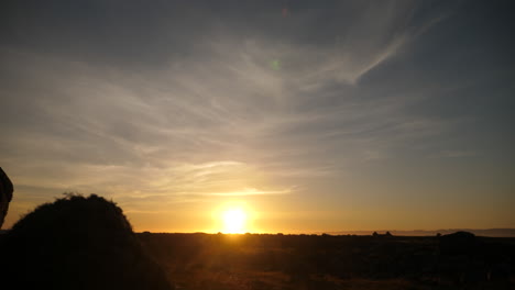 Slider-shot,-of-a-sunset-at-the-north-sea,-tracking-left-with-a-rock-in-the-foreground,-on-a-sunny-evening,-on-the-Norwegian-coast,-in-in-Lista-Vest-Agder-county,-in-Norway