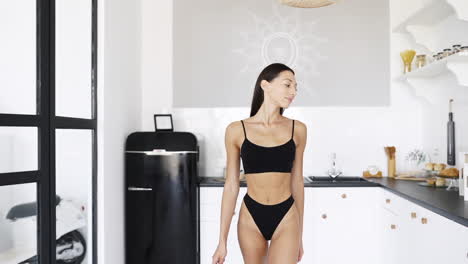 woman in black lingerie in a modern kitchen