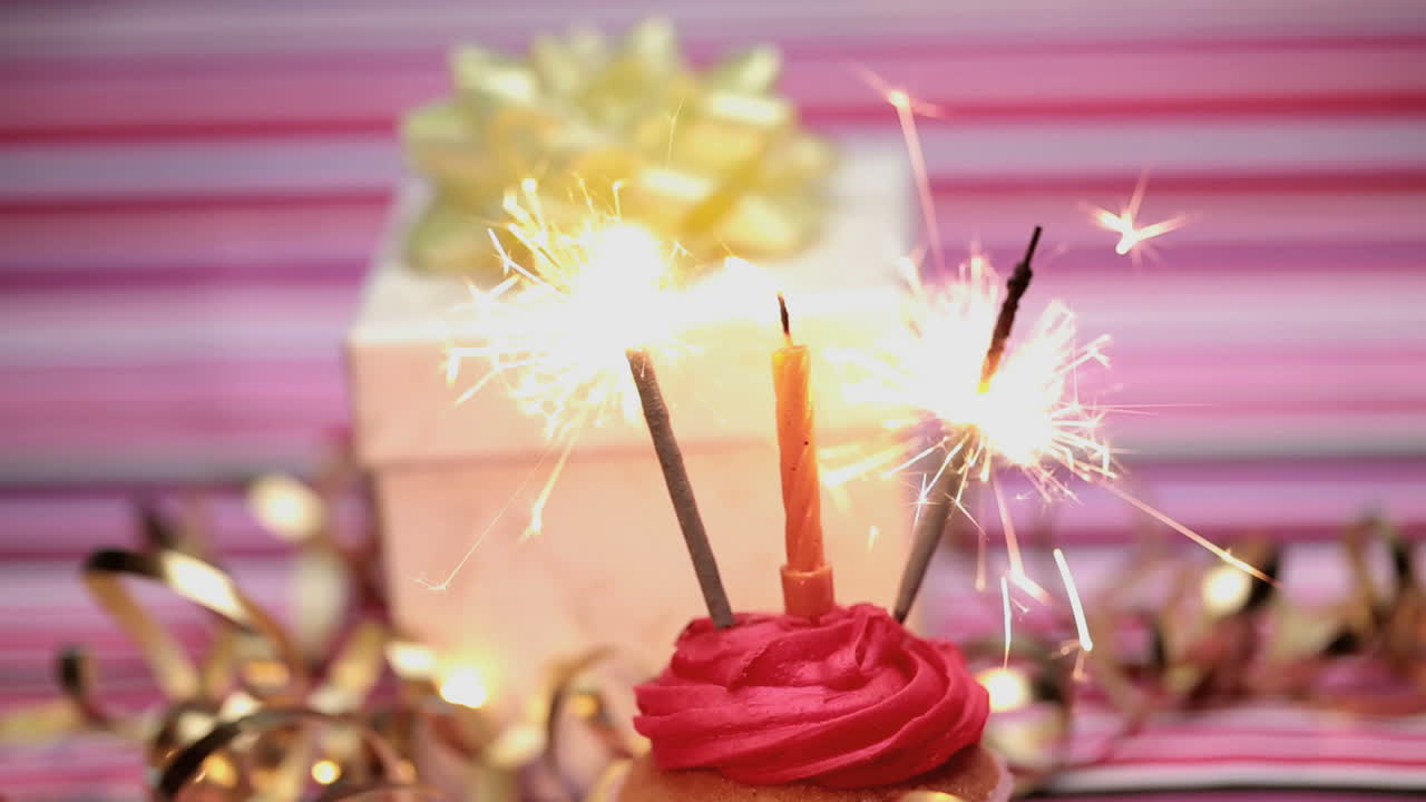 chispas en un pastel de cumpleaños con regalo