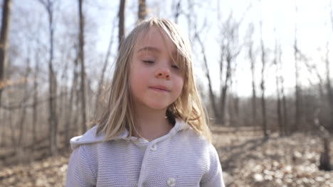 Slow-motion-outdoor-portrait-of-a-little-girl-in-a-forest-on-a-sunny,-autumn-day