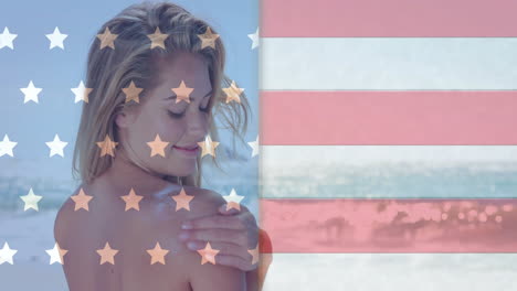 animation of flag of usa over caucasian woman on beach in summer