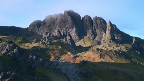 Flying-towards-crumbling-ancient-landslip-mountain-with-volcanic-plug-rock-spire-The-Old-Man-of-Storr,-early-morning-in-winter