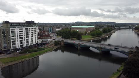 drone se desliza lateralmente a través del río trent por el puente de london road en nottingham mientras los coches cruzan en un día nublado de verano