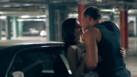 close-round-motion-man-hugs-and-kisses-woman-near-car