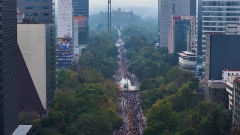 aerial descending shot of paseo de la reforma in mexico city during the day of the dead parade