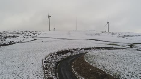 campo de montaña de invierno turbinas de viento en tierras altas rurales vista aérea frío valle nevado ladera aumento inclinación hacia arriba