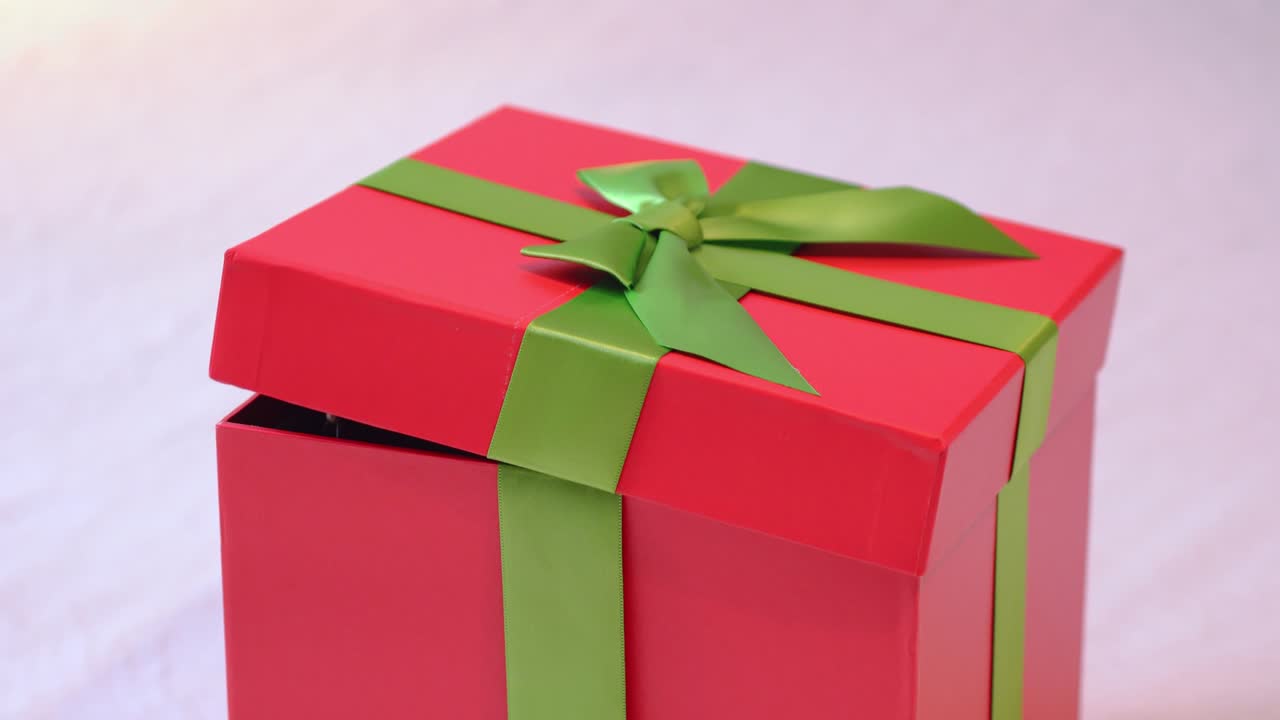 el pequeño cachorro salta de una caja de regalo roja de cartón. pinscher en miniatura negro y marrón.