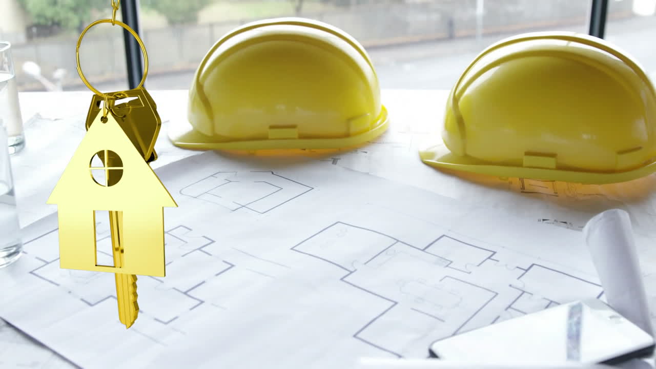 llaves de la casa y llaves colgando sobre el dibujo arquitectónico y cascos duros en el fondo