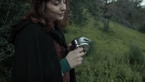 young melancholy woman charge the alarm clock in nature outdoor