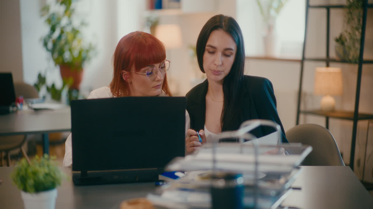 Kolleger diskuterer ved et skrivebord på et kontor