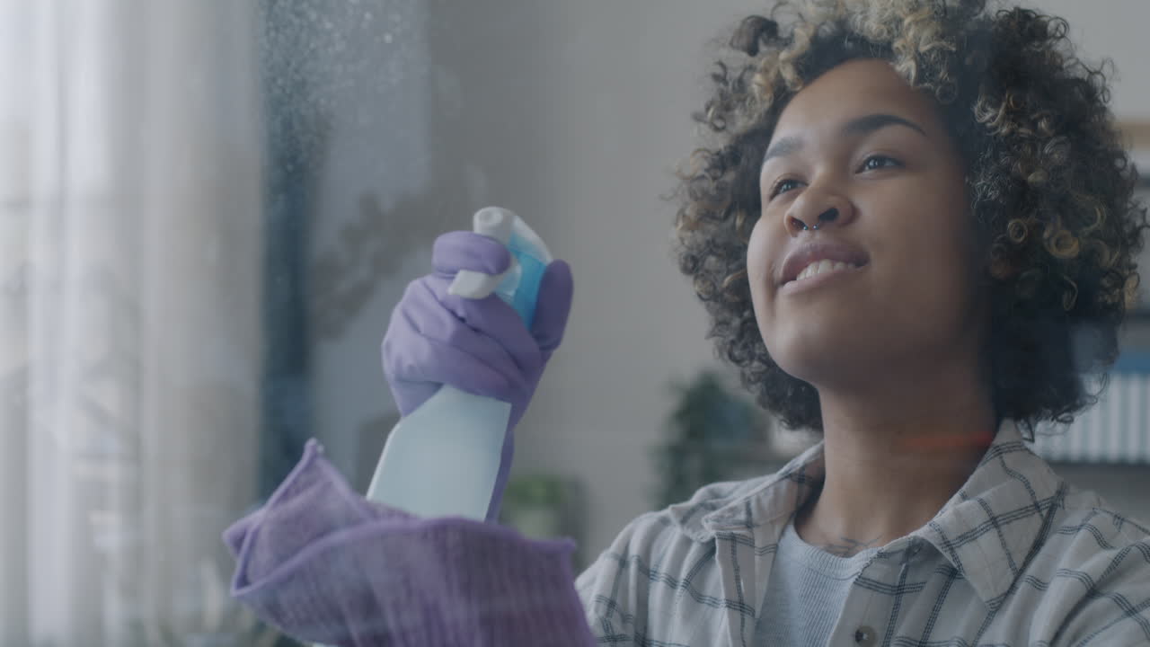 Young woman cleaning window