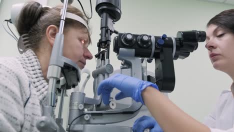la mujer está viendo a través del oftalmoscopio en los ojos del paciente en la clínica oftalmológica. inspección profesional de la visión