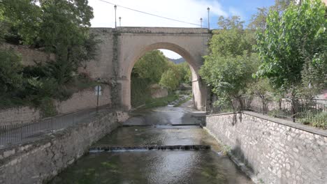 stone arch bridge over a calm river