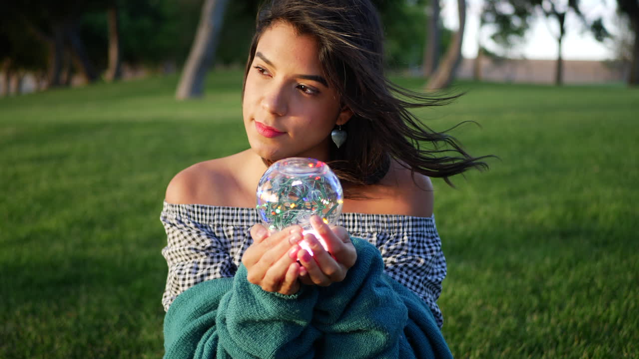 A beautiful and mysterious gypsy enchantress or fantasy character holding a magic glowing crystal ball