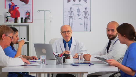 senior specialist man doctor explaining treatment to colleagues