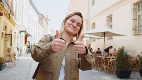 happy girl showing thumbs up like gesture positive something good positive feedback on city street