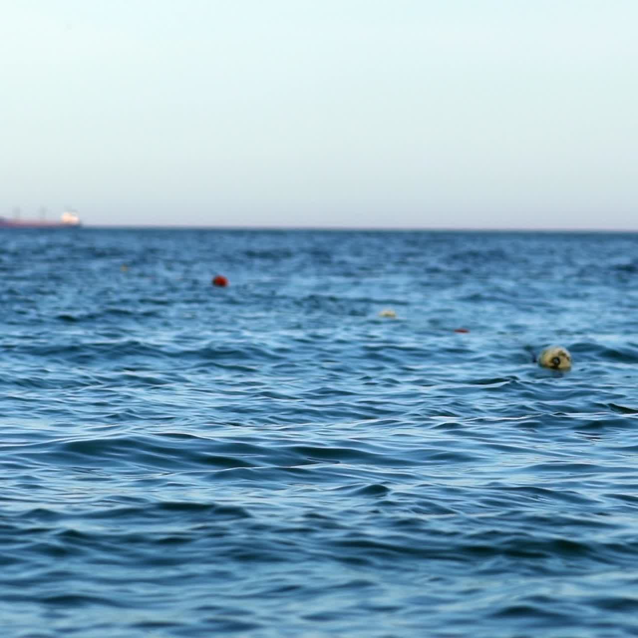 Floating buoys on water surface. Beautiful sea background. Breathtaking view of blue water under clear sky.