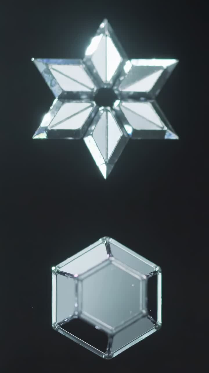 Vertical video: Shimmering six-pointed star and hexagon catching directional light in dark studio