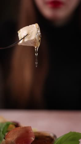 woman eating cheese with honey