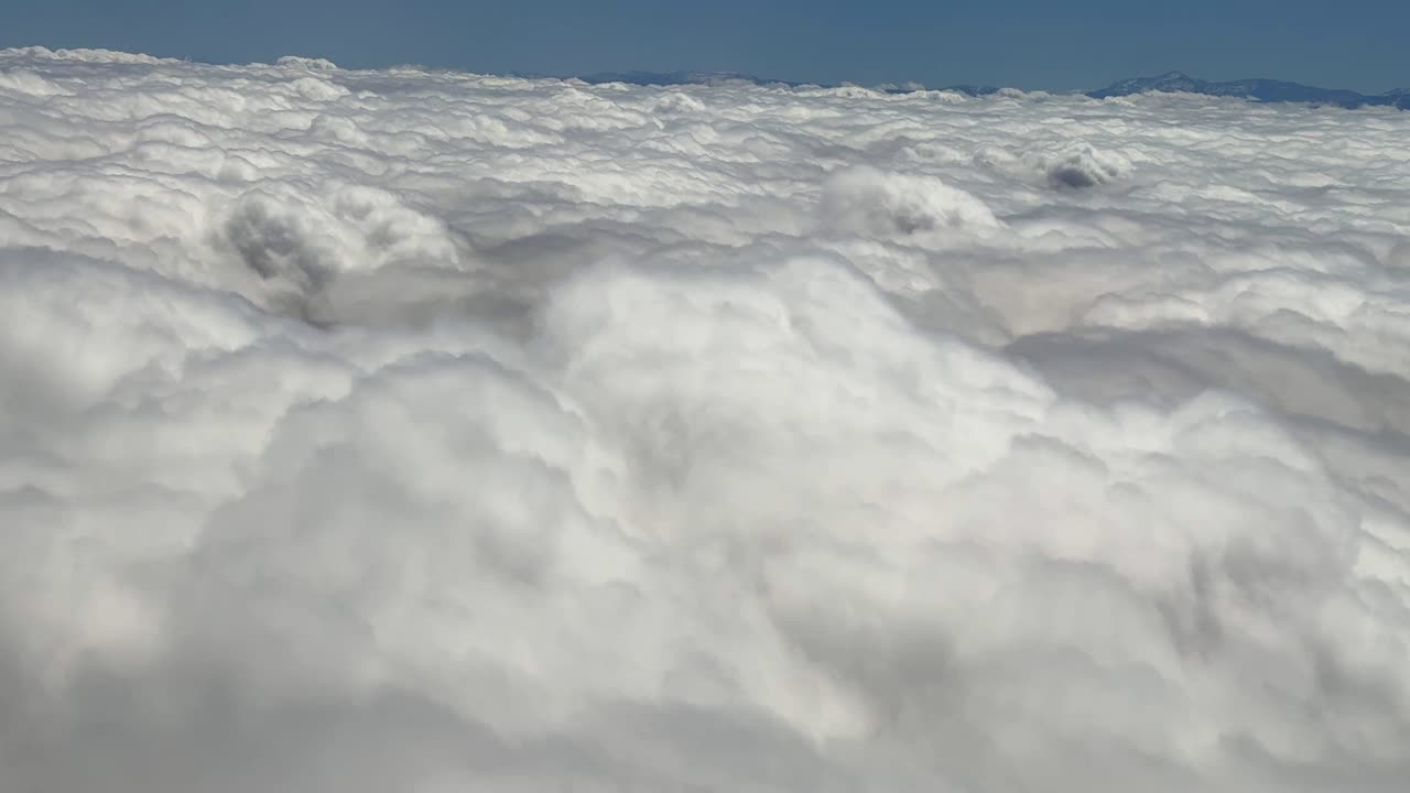 Above dense clouds formation, window view from airplane Atlas Mountains landscape