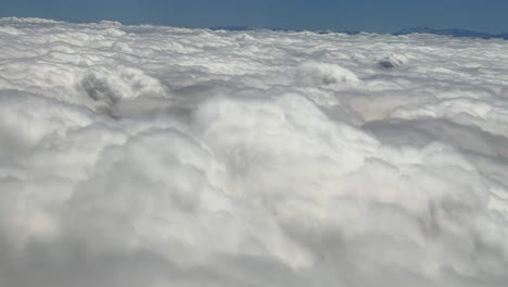 above dense clouds formation, window view from airplane atlas mountains landscape