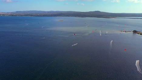 Panorama-Drohnenaufnahme-Eines-Kitesurf-Wettbewerbs-In-Punta-Tretto,-San-Giovanni-Suergiu,-Südsardinien,-Italien