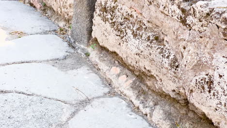 Nahaufnahme-Des-Antiken-Römischen-Steinbodens-In-Pompeji,-Italien,-Mit-Sichtbaren-Abnutzungsmustern,-Die-Eine-Geschichte-Des-Täglichen-Lebens-In-Einer-Stadt-Erzählen,-In-Der-Die-Zeit-Stehengeblieben-Ist