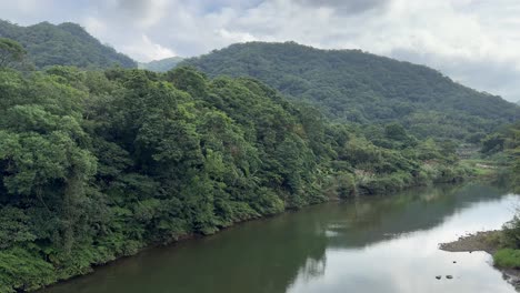 Schwenkaufnahme-Der-Malerischen,-Ruhigen-Landschaftsansicht-Des-Faszinierenden-Flusses-In-Der-Nähe-Des-Shifen-Wasserfalls-Im-Bezirk-Pingxi,-Neu-Taipeh,-Taiwan