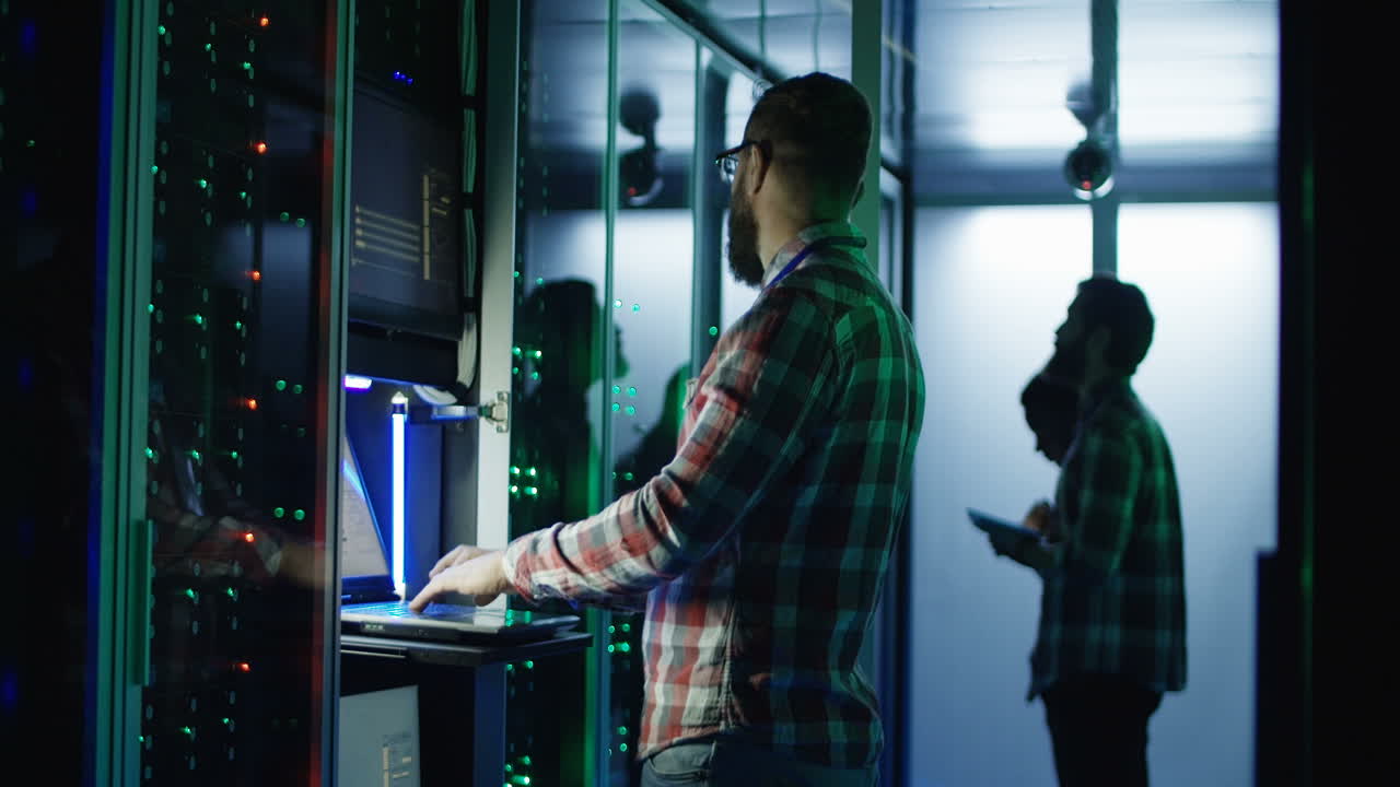 IT Technician Working in Server Room at Night