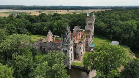 tilt up shot of old castle in the middle of the forest, kopice, poland