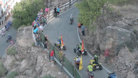 motorcyclist march with spanish flags on a mountain road with public