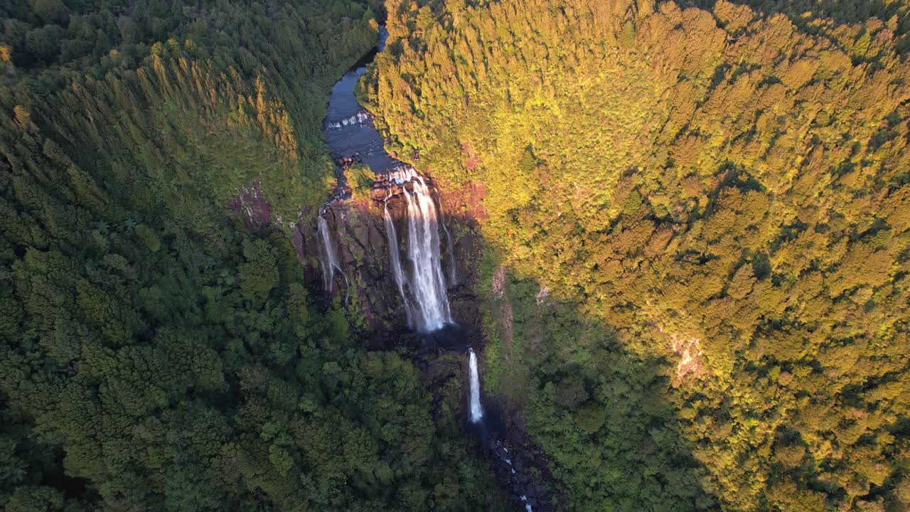Majestic Waterfalls and Lush Forest in an Aerial Golden Hour Landscape