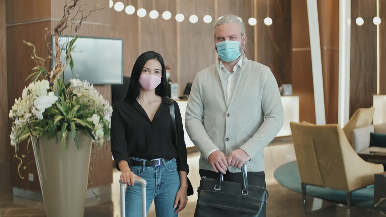 Couple in Face Masks in Hotel Lobby