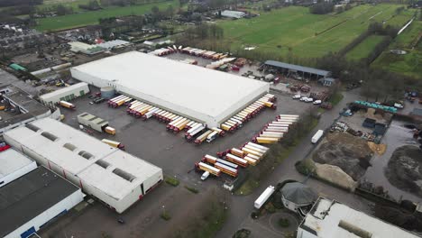 Stunning-aerial-of-large-transportation-company-with-trucks-parked-on-lot