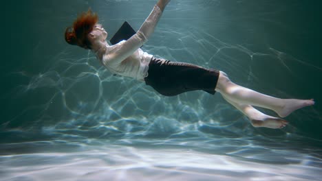 stress disorder. young business woman sinks under water with smart phone in hand slow motion. information overload.