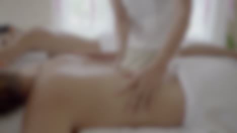 Blurry-background-of-a-couple-getting-a-massage-at-a-professional-spa-saloon,-body-care-concept-with-copy-space
