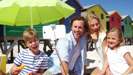 Family-taking-selfie-on-mobile-phone-at-beach