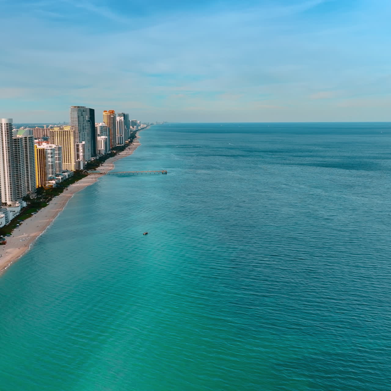 Calm blue waterscape of the Atlantic Ocean near the coast of America. Stunning view of Miami architecture on the coastline from top view.