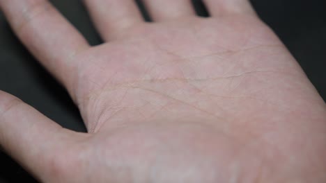 person delicately picks up silver chain placed on palm, capturing grace and elegance