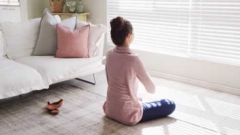 Kaukasische-Frau-Sitzt-Auf-Dem-Boden,-Praktiziert-Yoga-Und-Meditiert-Im-Wohnzimmer