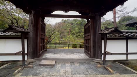 walking through entrance gate of konchi-in temple revealing lake on rainy day