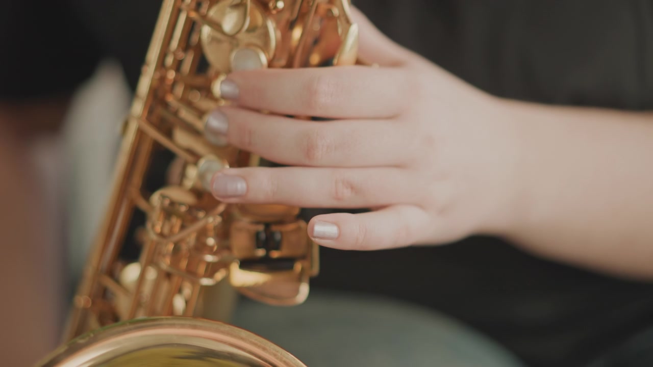 Mani in primo piano sui tasti del sassofono durante la pratica, studio dettagliato della diteggiatura con ottone lucido, sfondo neutro da studio, prova dello studente incentrata su articolazione e tempismo, feedback implicito dell'istruttore