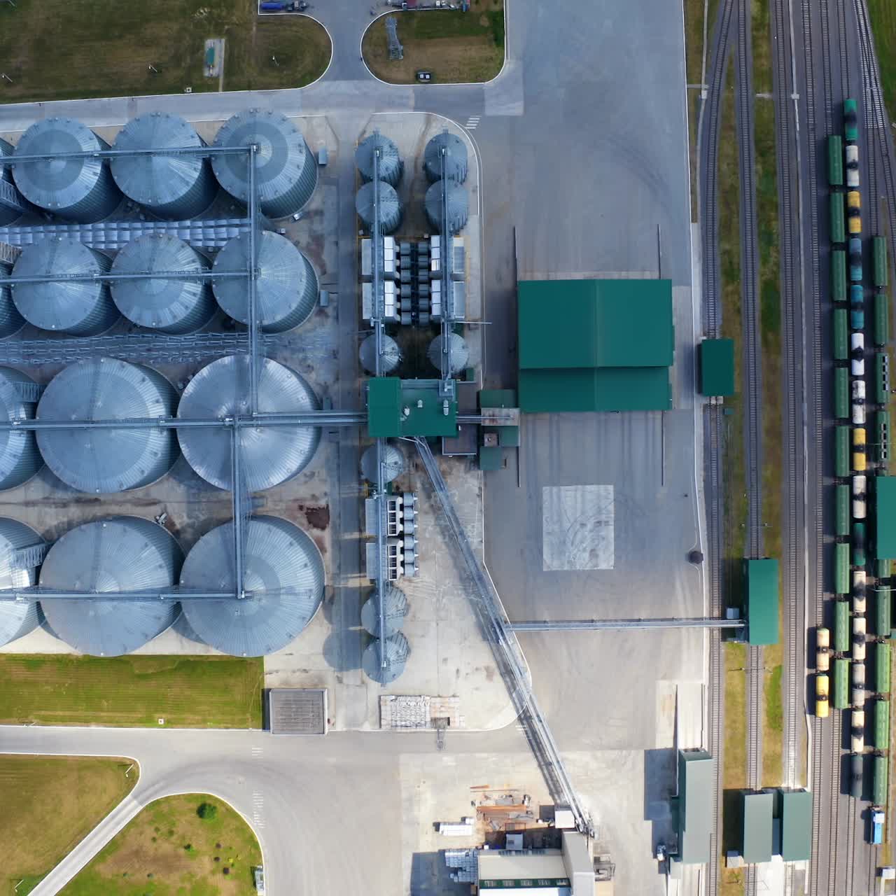 Metal equipment on a modern granary. Silos for keeping crop on field. Modern industrial complex with large grain elevators. Top aerial view