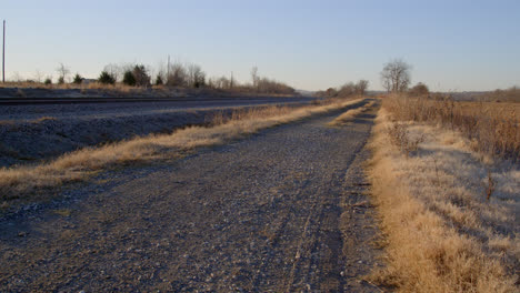 gravel road next to the railroad in texas country during the winter