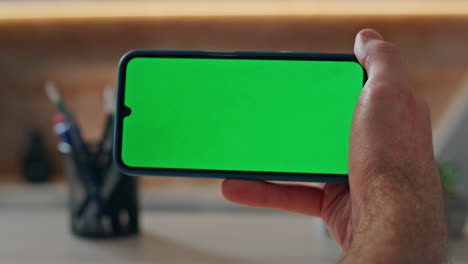 guy finger swiping greenscreen cellphone morning office closeup. boss scrolling
