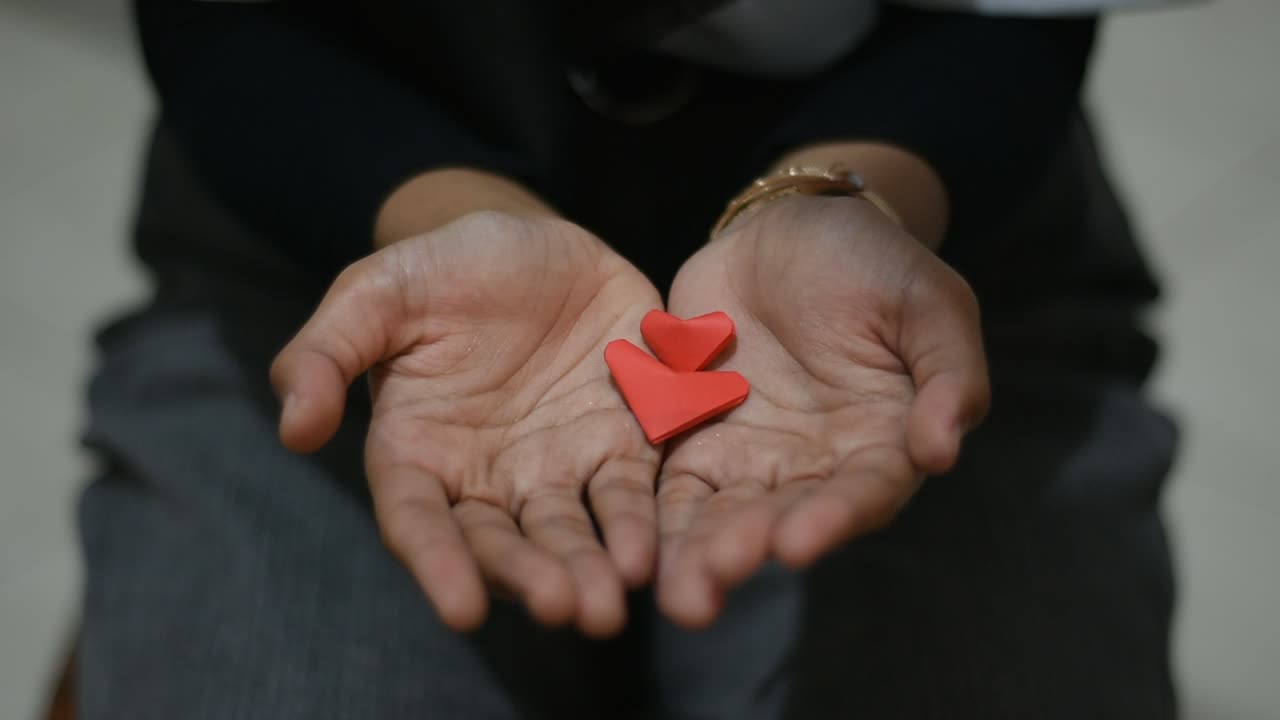 woman's hand was given a red heart-shaped paper