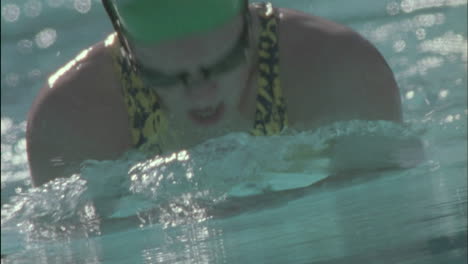 a swimmer ducks under the water and comes up repeatedly