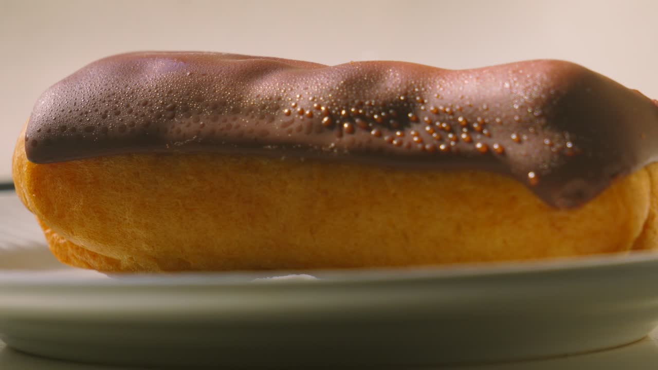 Pan Up to Delicious Eclair Topped with Chocolate and Puff Pastry Filled with Whipped Cream. Traditional Fresh French Dessert Ready to Eat and Enjoy. Food Photography.