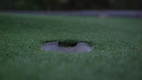 golf ball rolling into hole in slow motion