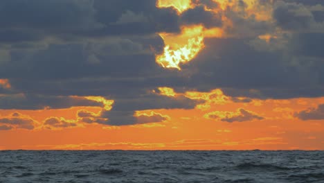 Romantic-vibrant-scenic-red-sunset-over-the-Baltic-beach-at-Liepaja-with-vibrant-blue-clouds,-wide-shot